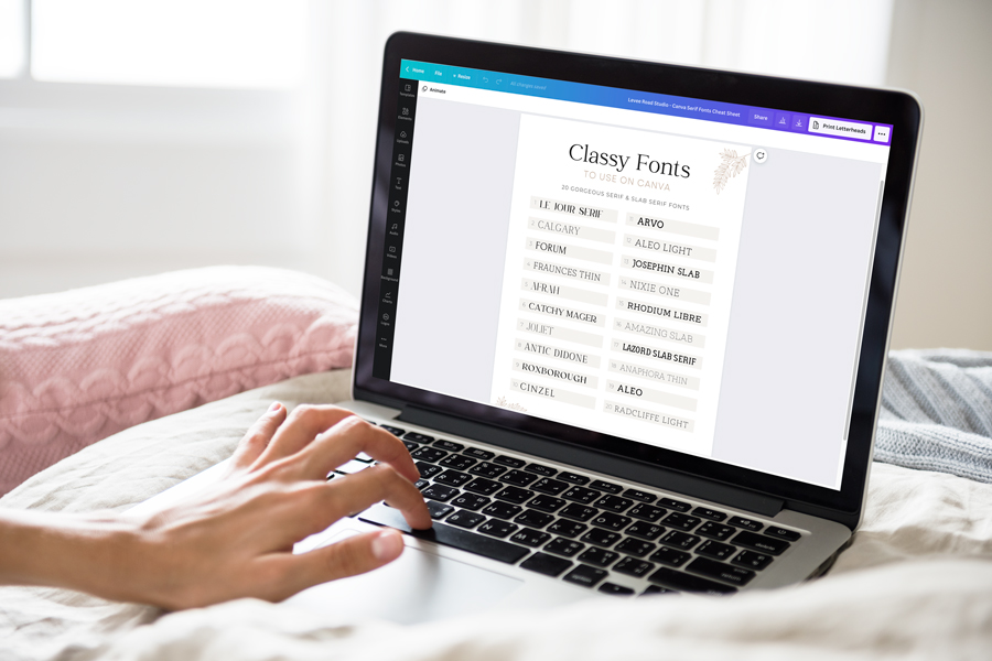 hand typing on laptop with preview of canva serif font cheat sheet